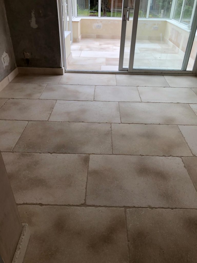 Bath Limestone installed in a living room flowing to the conservatory.  Both rooms have limestome skirting boards.