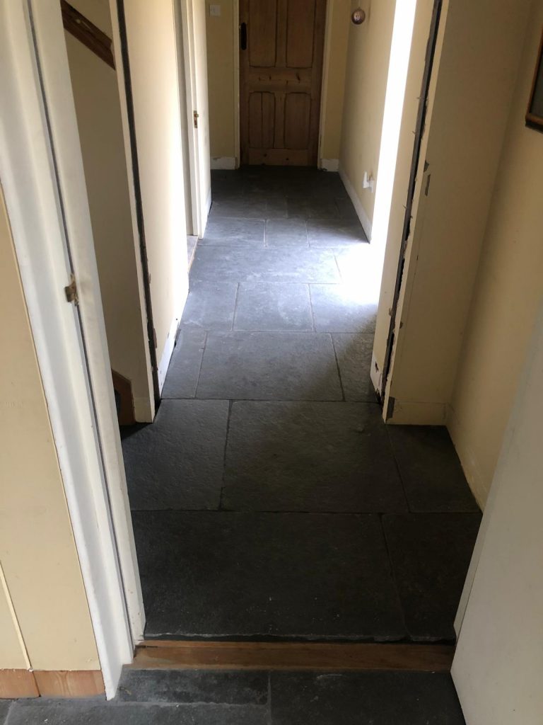 Installed Southwell limestone flooring in a hallway with tumbled edges creating an aged, traditional stone appearance.