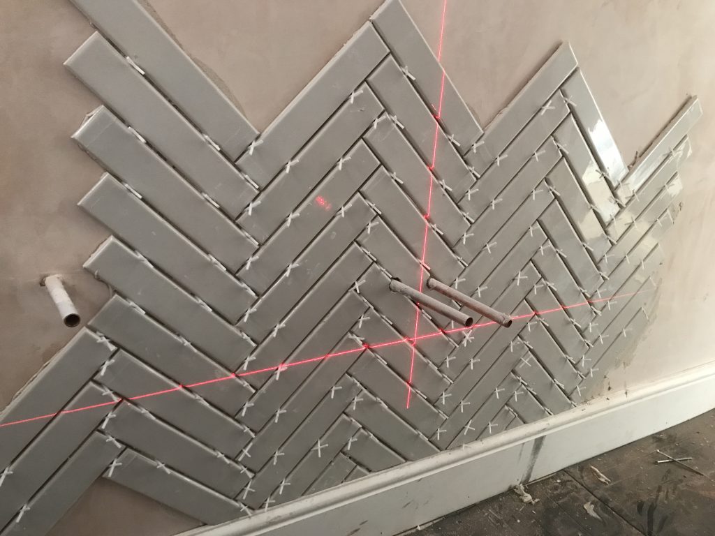 herringbone ceramic bathroom wall tiles installation with spacers and laser lines Worcester
