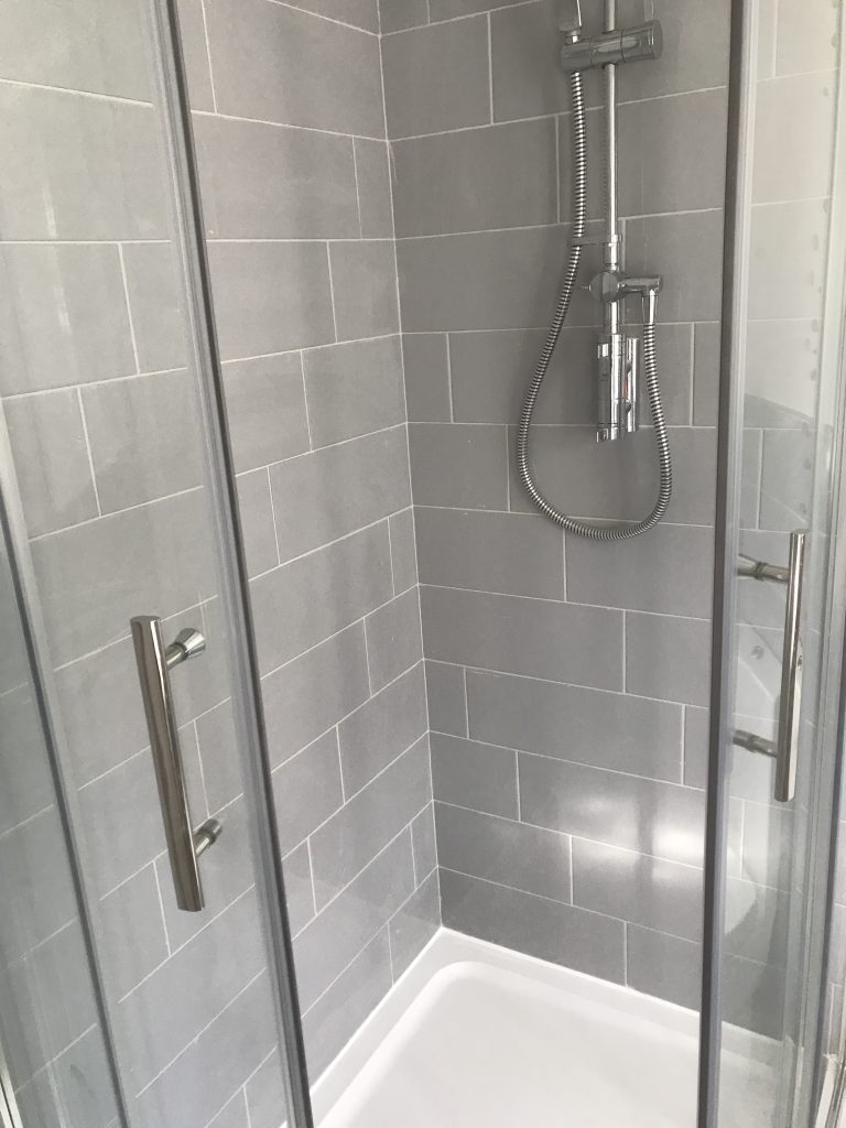 grey porcelain bathroom wall tiles in shower cubicle with fitted shower and glass doors Worcester

