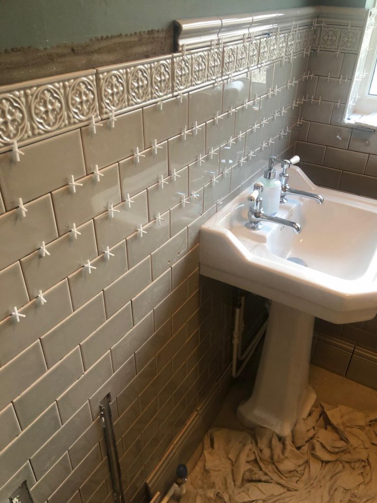 Bathroom wall tiles installation showing levelling clips and spacers