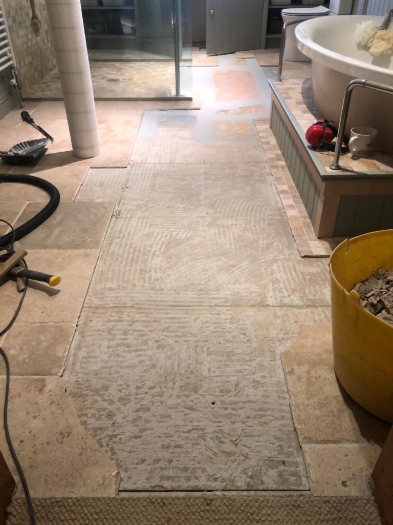 long view of the bathroom floor showing the repairs at the far end and where all the tiles had cracked and needed replacements.