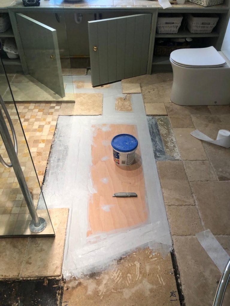Tile flooring Dorset showing new wooden floor installation with tanking kit used to seal joints prior to anti fracture mat fitting.